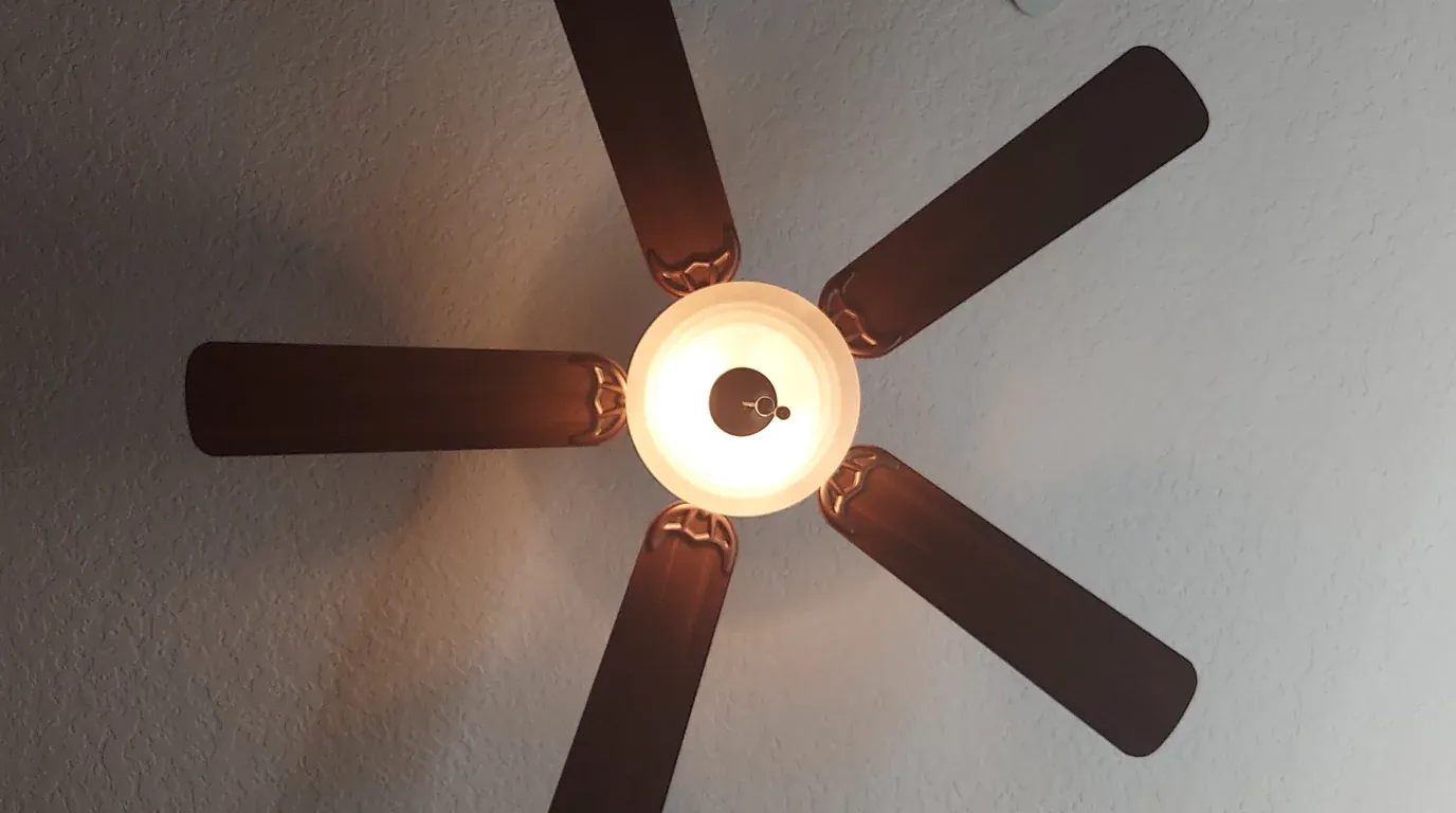 Lighting and Ceiling Fan Repair equipment - modern residential ceiling fan with illuminated central lighting fixture and mounting hardware